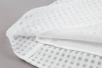 White fabric with a subtle pattern on a gray background