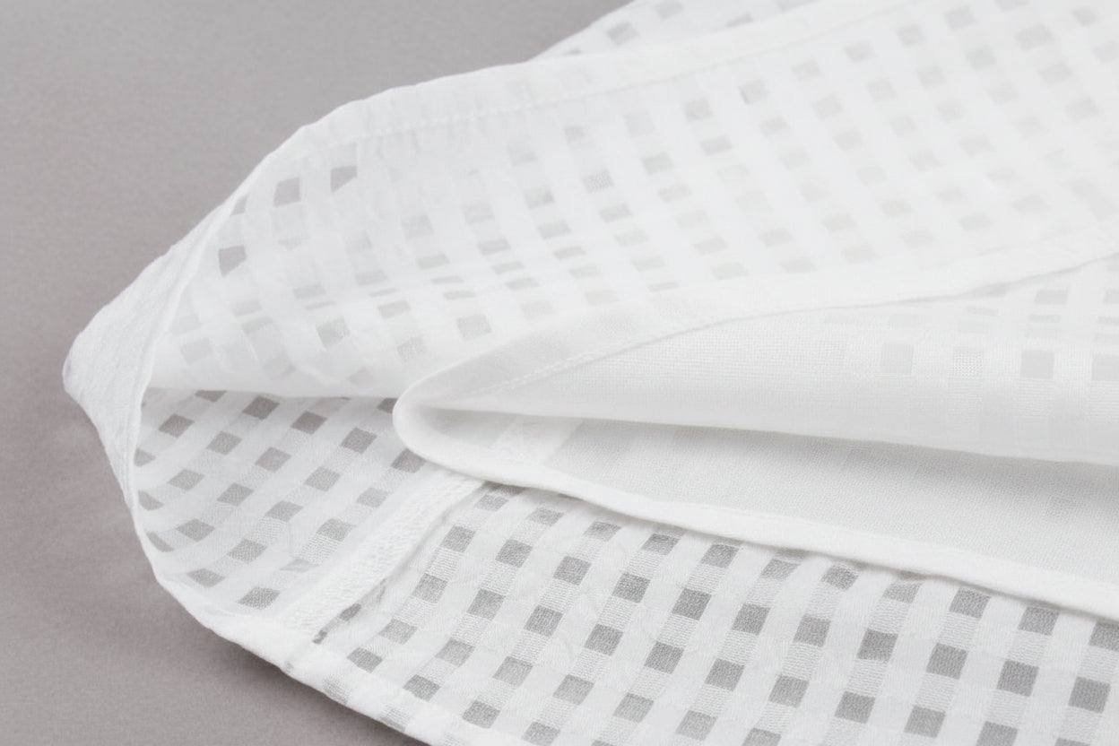 White fabric with a subtle pattern on a gray background